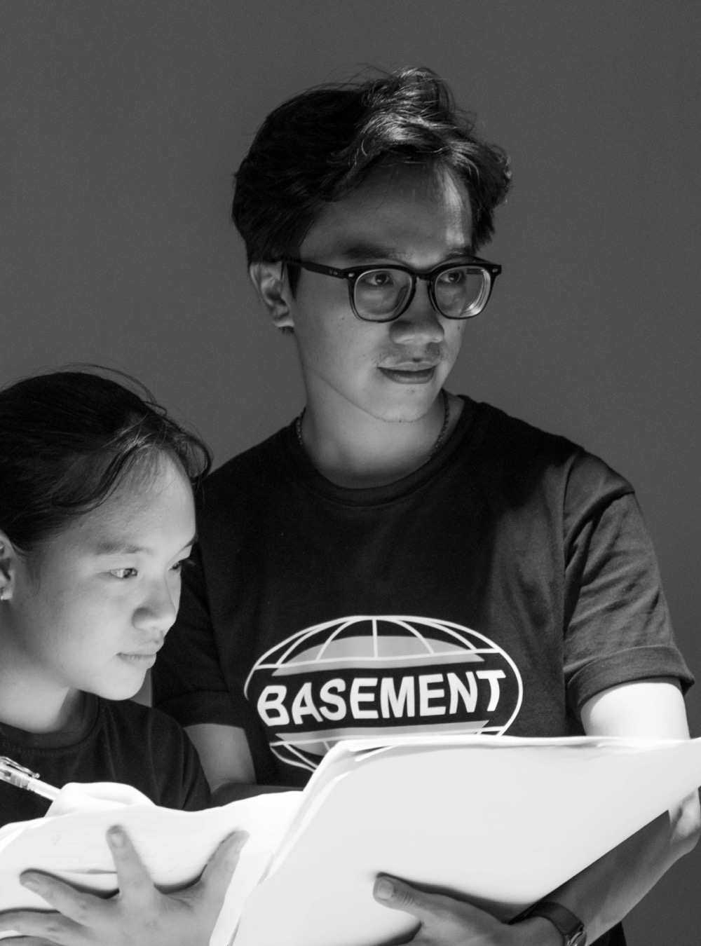 Duy reading a script with a colleague, black and white
