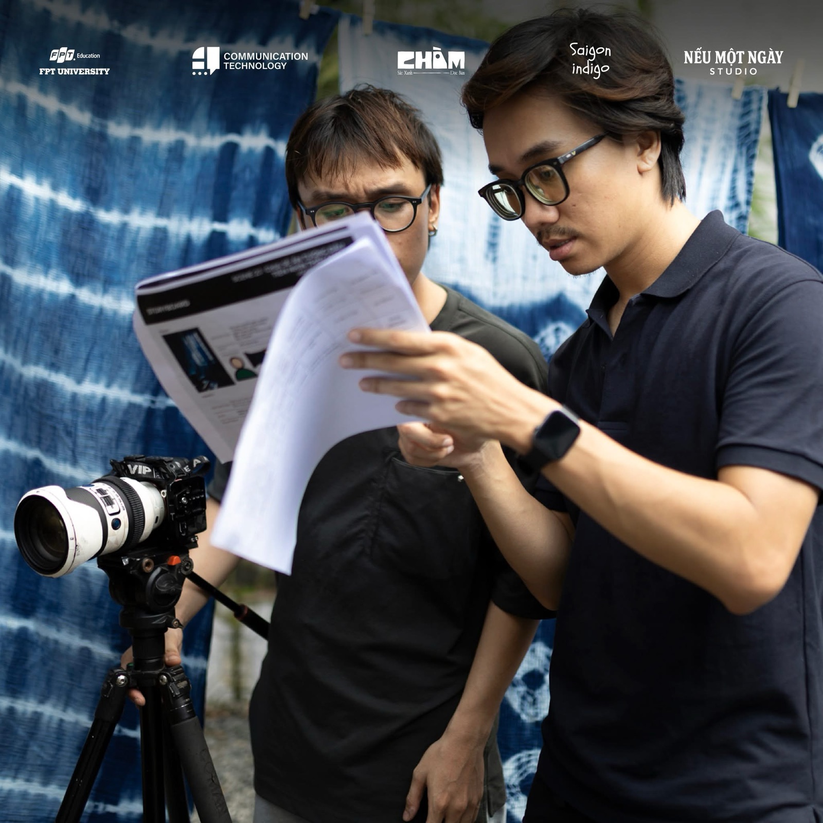 Duy checking the storyboard with a crew member on the set of Chàm Workshop